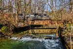 NS 6320 leads H75 across a plate girder bridge in Housenick Memorial Park, Bethlehem Township